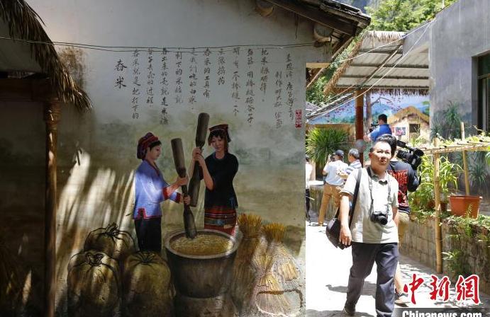 艺术家将当地自然、人文环境、黎乡故事等画在村民居所墙壁上，打造“流动的黎族文化博物馆”。　记者王晓斌 摄